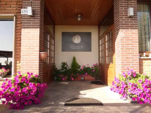 a building with purple flowers on the side of it at La LocAnna in Serramazzoni