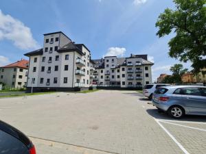 a parking lot with cars parked in front of a building at Apartament in Legnica