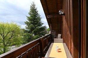 a wooden balcony with a table and a christmas tree at Gästehaus Huber in Immenstaad am Bodensee