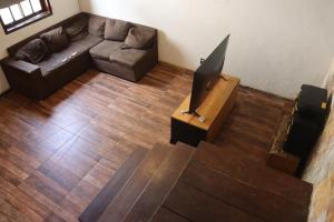 a living room with a couch and a television at Republica Do Arco Da Velha in Ouro Preto
