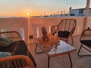 a patio with a table and chairs and a sunset at Amelie apartments in Naxos Chora +7 photos