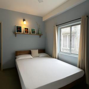 Un dormitorio con una cama grande y una ventana. en The Aura 2BHK near Paltan bazar, en Guwahati