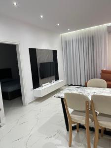 un salon avec une table, des chaises et une télévision dans l'établissement Eldi's Home, à Vlorë 19 autres photos