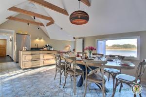a kitchen and dining room with a table and chairs at La maison bleue in Trégastel