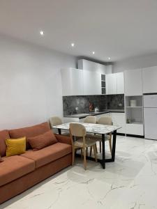 un salon avec un canapé et une table et une cuisine dans l'établissement Eldi's Home, à Vlorë