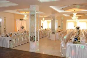 a banquet hall with white tables and white chairs at Zajazd Primavera in Kraśnik