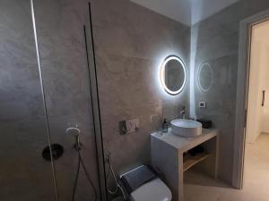 a bathroom with a shower and a sink and a mirror at Amelie apartments in Naxos Chora