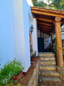 a porch of a house with a wooden roof and stairs at Torreon de Nubla in Cazorla