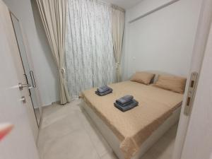een slaapkamer met een bed met twee handdoeken erop bij Sunny Apartment in Ofrínion