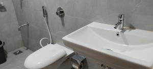 a bathroom with a white toilet and a sink at Hotel Sara Executive in Pune +24 photos