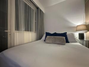 a white bed with a pillow on top of it at Seaside Manila Bay Sunset View at SM Mall of Asia in Manila +53 photos