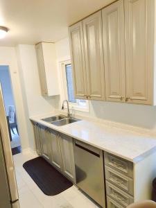 a kitchen with white cabinets and a sink at Pickering Your home away from home in Pickering