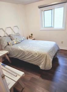 a bedroom with a bed with a white comforter at Pickering Your home away from home in Pickering