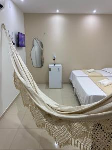 a bedroom with a hammock in a room at Suite no Centro da Praia de Flecheiras in Trairi
