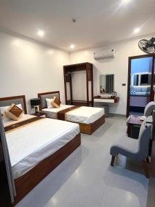 a hotel room with two beds and a chair at The Horizon Hotel in Ða Gia +35 photos
