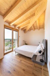 a bedroom with a bed and a large window at IL Pollaio in Farra di Soligo
