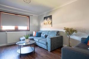 ein Wohnzimmer mit Sofa und Tisch in der Unterkunft Mercer Apartment in Alloa