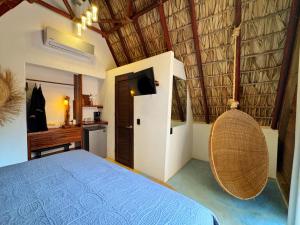 une chambre avec un lit et une télévision dans une pièce dans l'établissement Aldea Kanaloa Hotel Puerto Escondido, à Brisas de Zicatela