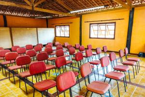 a room with red chairs and tables in it at VELINN Hotel Fazenda Estrela da Serra in Santo Antônio do Pinhal