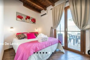 a bedroom with a bed with a pink blanket at Sardegna Relax House in Quartu SantʼElena