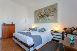 a bedroom with a bed and a painting on the wall at Dimora Aurelia Rome & Sea in La Massimina-Casal Lumbroso
