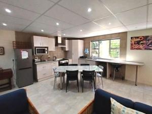 a kitchen with a table and chairs in a room at Ce-la-vie in Gqeberha