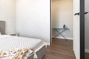 a bedroom with a bed and a table in a room at Aruna Deluxe Apartment идеально для туриста in Astana
