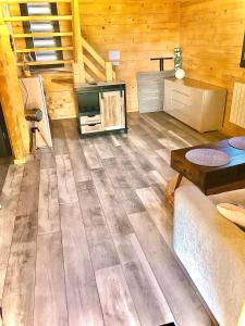 a living room with wooden walls and wooden floors at Chalet au calme pour 6 personnes proche Golfe du Morbihan Animaux acceptés in Sulniac +9 photos