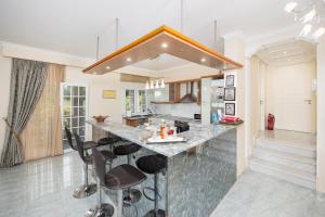 eine Küche mit einer großen Theke mit Hockern in der Unterkunft Villa Psaropouli in Dragotiná