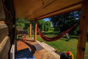 a hammock on a porch of a house at Siedlisko Sobibór in Sobibór