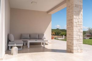 a patio with a couch and a table at Villa Juki by Briskva in Kaštel