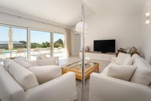 a living room with white furniture and a television at Villa Juki by Briskva in Kaštel