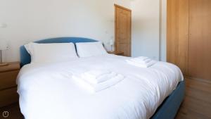 un letto bianco con due asciugamani sopra di Italianway - Milano 35 a Bormio