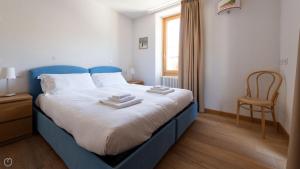 una camera da letto con un letto blu con sopra degli asciugamani di Italianway - Milano 35 a Bormio