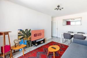 a living room with a couch and a tv and a table at GuestReady - Excelente Aptos perto de Antique District in Saint-Ouen