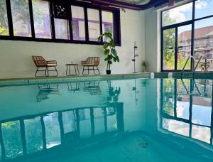 a swimming pool with two chairs and a table at APM Inn and Suites in Winchester