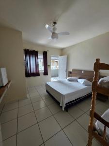 a bedroom with a bed and a ceiling fan at Pousada Buenos Aires in Pontal do Paraná