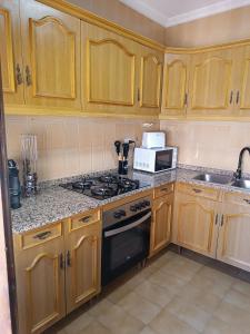 une cuisine avec des armoires en bois et un four à plaques de cuisson dans l'établissement Casa Corzo, à María 12 autres photos