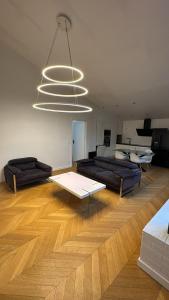 サン・モール・デ・フォッセにあるCosy F2 à Saint Maur des Fossésのリビングルーム(ソファ2台、大きなシャンデリア付)