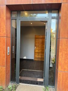 ein Eingang zu einem Gebäude mit Glastüren in der Unterkunft Cosy F2 à Saint Maur des Fossés in Saint-Maur-des-Fossés