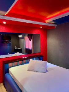 a room with two beds and a red wall at Agha Motel in Canela