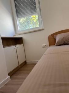 a bedroom with a bed and a window at StanČapljina in Čapljina