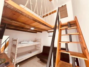 a room with a loft bed and a ladder at Atenas - Lofts com Cozinha - Próximo Aeroporto e Rodoviária in Porto Seguro