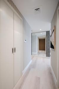 an empty hallway with white walls and wood floors at 2BR Private Apartment in Al Zahia, Sharjah - Stone Haven in Sharjah