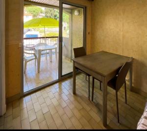 a table and chairs in a room with a patio at L'Escapade au Canigou in Vernet-les-Bains