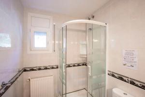 a bathroom with a shower and a toilet and a window at Villa CARMENÇÓ in Empuriabrava +36 photos