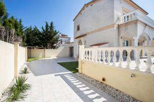 a house with a white fence and a staircase at Villa CARMENÇÓ in Empuriabrava