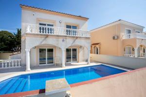 una villa con piscina frente a una casa en Villa CARMENÇÓ, en Castelló d'Empúries