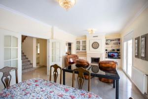Una sala de estar con mesa de comedor y sillas. en Villa CARMENÇÓ, en Castelló d'Empúries