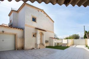 una gran casa blanca con garaje en Villa CARMENÇÓ, en Castelló d'Empúries